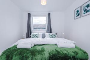 Stunning 3 br house near Leeds City Centre with Free Parking في Hunslet: سرير كبير في غرفة بيضاء مع نافذة