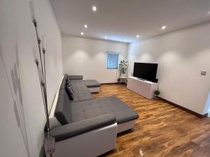 a living room with a couch and a flat screen tv at Westcliff-on-Sea Coach house in Westcliff-On-Sea