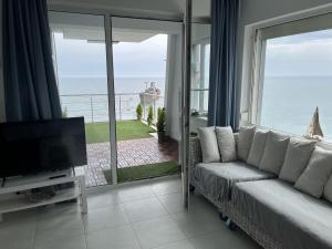 a living room with a couch and a view of the ocean at Apartament Costinești vedere epavă in Costinesti