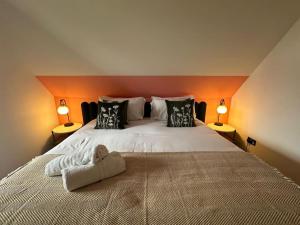 a bedroom with a large white bed with two lamps at The Old Post Office in Bishops Waltham