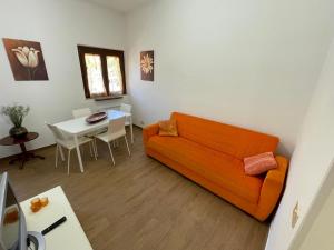 sala de estar con sofá naranja y mesa en Il Glicine di Luna, en Torrimpietra