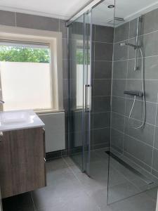 La salle de bains est pourvue d'une douche en verre et d'un lavabo. dans l'établissement Spacious holiday home, centrally located, near National Park, à Soest