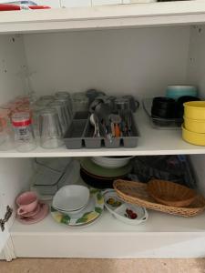 a white cabinet filled with dishes and other items at Appartement spacieux et lumineux in Vandoeuvre-lès-Nancy +1 photo