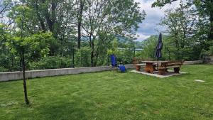 een picknicktafel en een paraplu in de tuin bij Hiša Bizjak in Kranj