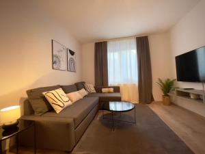uma sala de estar com um sofá e uma televisão de ecrã plano em 110qm - 4 Zimmer - privat Parkplatz - zentral - Balkon - MalliBase Apartments em Kassel