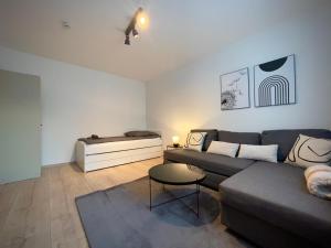 uma sala de estar com um sofá e uma cama em 110qm - 4 Zimmer - privat Parkplatz - zentral - Balkon - MalliBase Apartments em Kassel