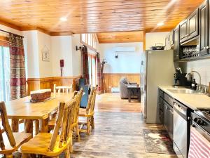 a kitchen and dining room with a table and chairs at ADK Cabin with Hot Tub, Near Whiteface, Lake Placid, Fire Pit, Game Rm in Jay