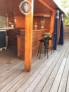 a wooden deck with a table and chairs on it at Maison bassin d'Arcachon 8 personnes, SPA, promo août in Le Teich