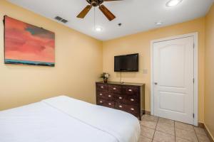 1 dormitorio con 1 cama y TV de pantalla plana en Lantana Retreat 4, en South Padre Island