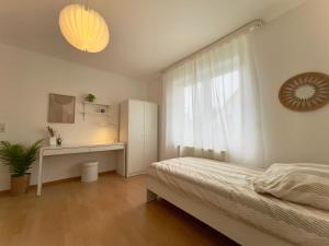 um quarto com uma cama, uma secretária e uma janela em 110qm - 4 Zimmer - privat Parkplatz - zentral - Balkon - MalliBase Apartments em Kassel