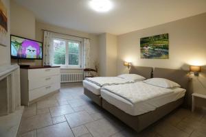 a bedroom with a bed and a television in it at Villa Seeblick am Strand in Flessenow +17 photos