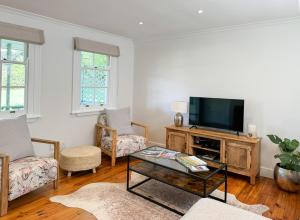 a living room with a tv and a coffee table at Valley View Cottages in Cape Town