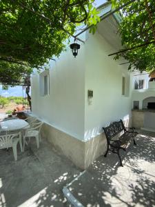 a white building with a table and chairs at Pedi’s house in Aspropótamos