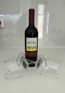 una bottiglia di vino seduta accanto a un paio di bicchieri di House Rio Almada ad Almada