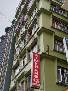 een gebouw met een rood bord aan de zijkant bij Zimkhang Guesthouse in Gangtok