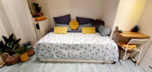 um quarto com uma cama com almofadas azuis e amarelas em Dantas Apartment em Nurembergue