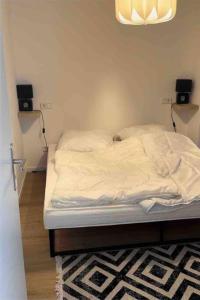 1 cama no hecha en un dormitorio con altavoces en la pared en Appartement DUS en Düsseldorf