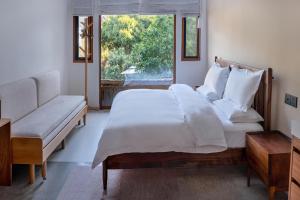Un dormitorio con una gran cama blanca y una ventana en Xianqingshan Homestay, en Hangzhou