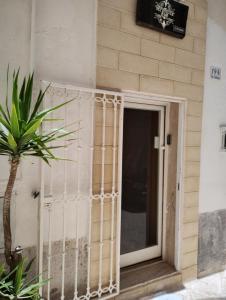 una puerta a un edificio con una planta delante en My House Suite, en Monopoli