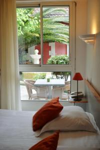 アルカションにあるHôtel Orange Marineのベッドルーム1室(ベッド1台、大きな窓付)