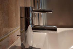 a silver faucet on a sink in a bathroom at Hôtel Orange Marine in Arcachon