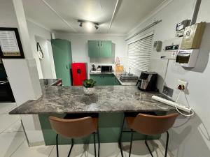 a kitchen with a counter with three bar stools at The Legacy in East London
