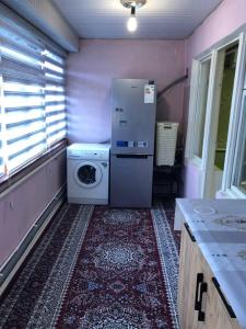 a kitchen with a refrigerator and a washing machine at Korzinka in Fergana
