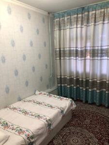 費爾干納的住宿－Korzinka，一间卧室配有两张床和窗帘