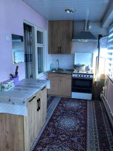 uma cozinha com um lavatório e um fogão forno superior em Korzinka em Fergana