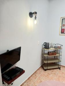 um quarto com uma parede branca com uma televisão e uma prateleira em Villa Tranquilla apartment em Oliveira do Hospital