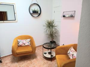 uma sala de estar com duas cadeiras e uma mesa em Villa Tranquilla apartment em Oliveira do Hospital