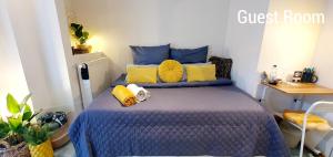 um quarto com uma cama azul e almofadas amarelas em Dantas Apartment em Nuremberga