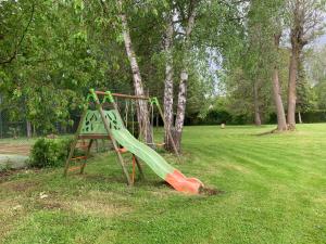 un parque infantil con un tobogán verde en Grand appartement indépendant de trois chambres proche Disney, en Isles-lès-Villenoy
