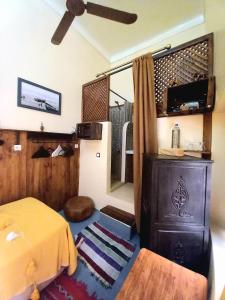 a bedroom with a bed and a dresser and a ceiling at Riad Alqimam in Marrakesh