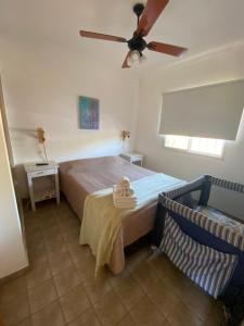 Schlafzimmer mit einem Bett und einem Deckenventilator in der Unterkunft Liwen Apartamentos de Playa in San Clemente del Tuyú