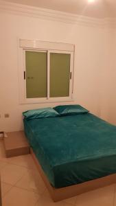 a bedroom with a large bed with a window at Appartement Taza in Taza