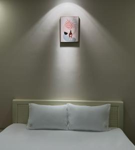ein Schlafzimmer mit einem Bett mit einem Bild an der Wand in der Unterkunft AT Hotel Cần Thơ in Ấp An Mỹ