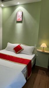 Un pat sau paturi într-o cameră la AT Hotel Cần Thơ