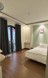ein Schlafzimmer mit einem Bett und einem großen Fenster in der Unterkunft AT Hotel Cần Thơ in Ấp An Mỹ