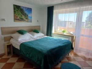 a bedroom with a bed and a large window at Dom Gościnny Raido in Gdynia