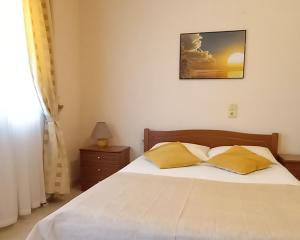 パレカストロにあるMaridatis Apartmentsのベッドルーム1室(黄色い枕2つ付きのベッド1台付)