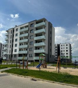 un edificio de apartamentos con un parque infantil delante de él en Apartament Zachodni, en Słupsk