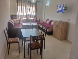 un soggiorno con tavolo, sedie e divano di Calmehome a Oujda