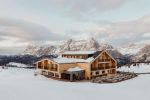 une maison au sommet d'une montagne enneigée dans l'établissement Rifugio Alpino Pralongià, à Corvara in Badia