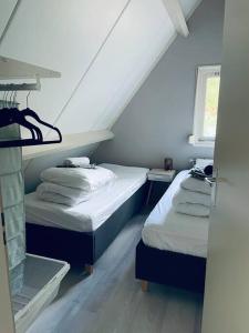 2 camas en una habitación con ático en Fijn vakantiehuis op de golfbaan met eigen sauna!, en Winterswijk Henxel