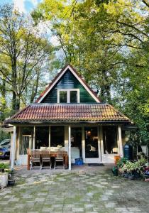 Casa pequeña con mesa y sillas en Fijn vakantiehuis op de golfbaan met eigen sauna!, en Winterswijk Henxel