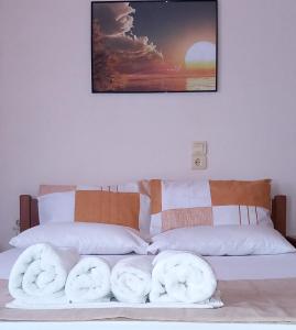 a bed with two white towels on top of it at Maridatis Apartments in Palekastron