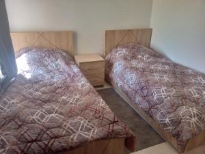 due letti uno accanto all'altro in una camera da letto di Calmehome a Oujda
