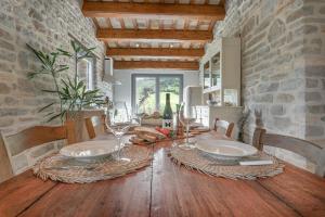 una sala da pranzo con tavolo in legno e bicchieri da vino di B&B Panfilo Farmhouse a Cellino Attanasio