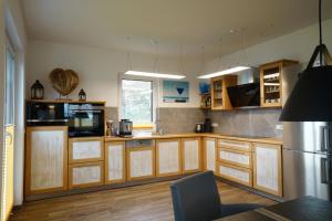 a large kitchen with wooden cabinets and a television at Villa Meermaid mit Schwimmbad in Hohen Wieschendorf